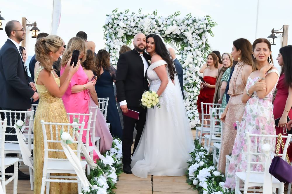 Bride and groom with their guests at the floral arch