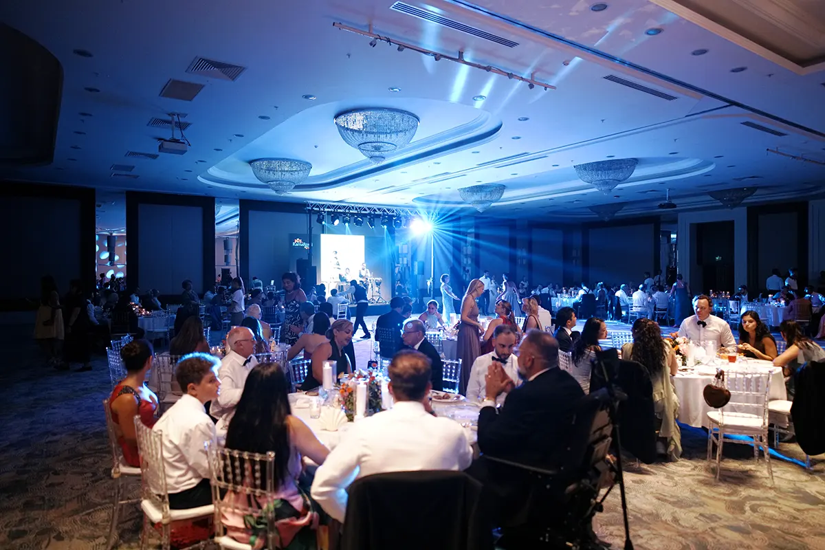 Indoor Persian wedding reception with round tables, stage and lighting in Antalya