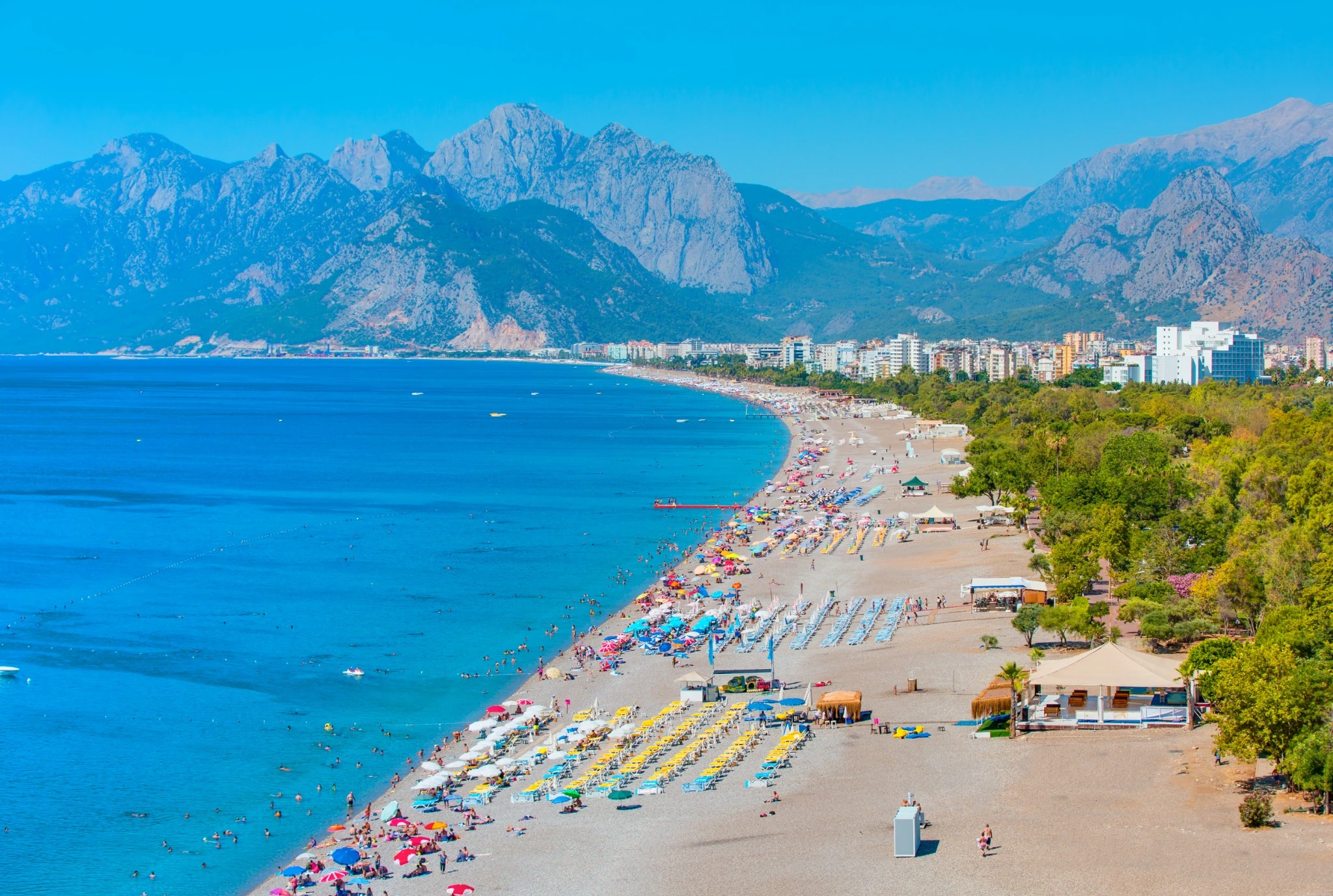 Konyaaltı Beach in Antalya with the Mediterranean Sea and Taurus Mountains in the background.