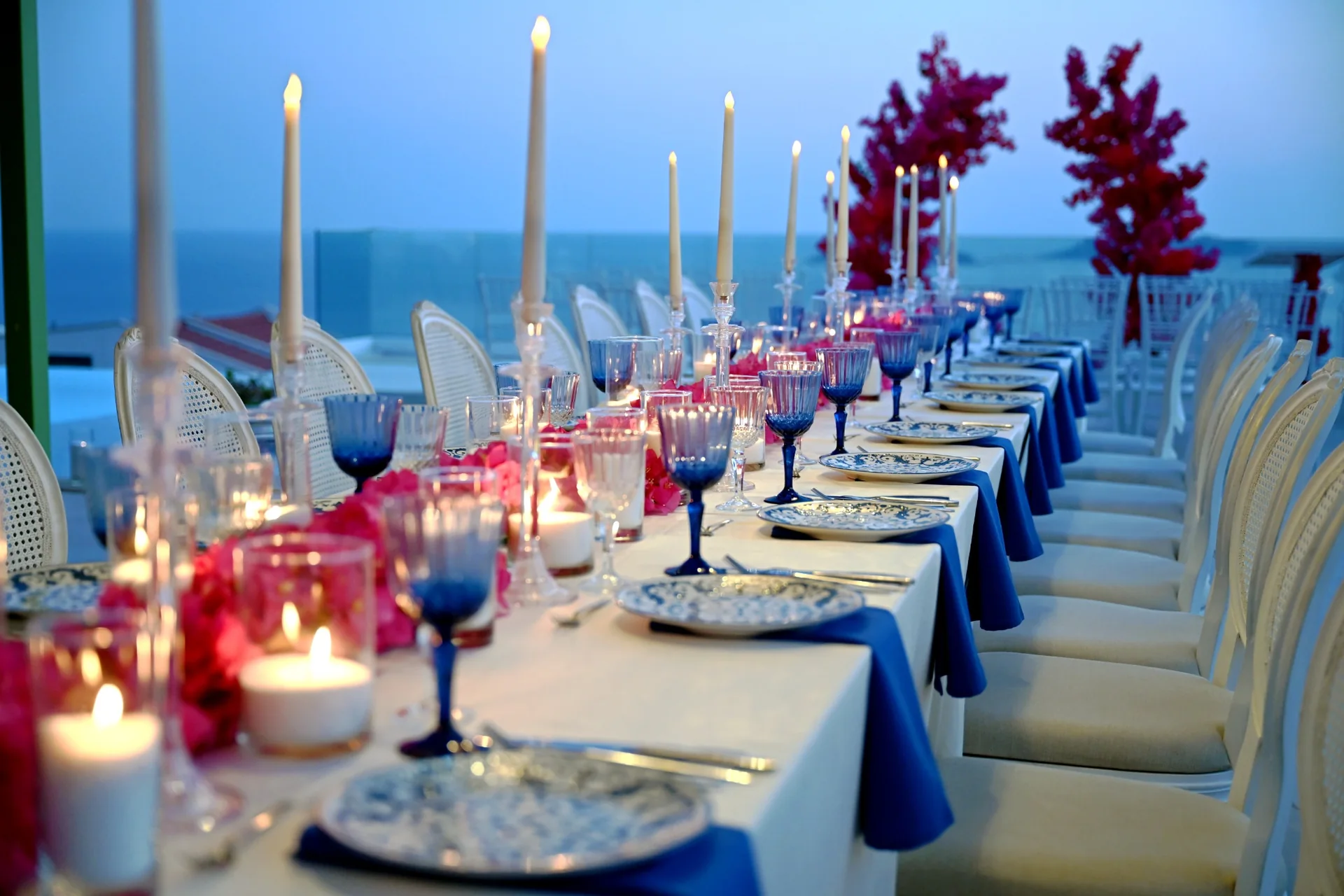 Seaside Antalya wedding reception table decorated with blue glasses and pink flowers