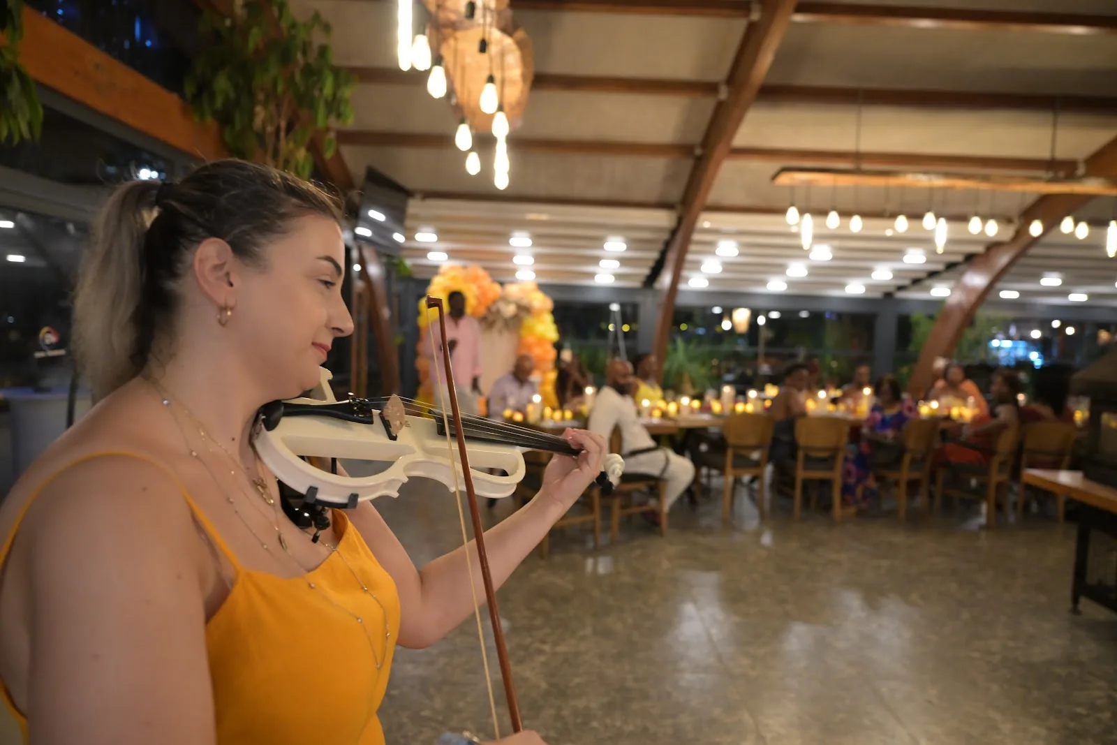Akşam davetinde misafirlere canlı keman performansı sunan müzisyen