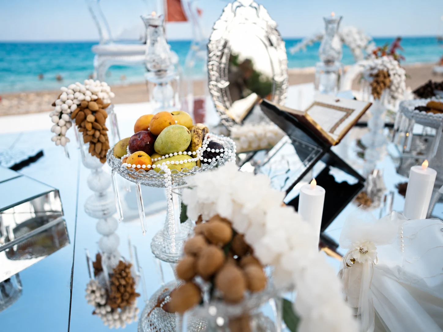 Traditional Sofreh Aghd details with mirror, fruit, candles and floral decorations beside the sea in Antalya